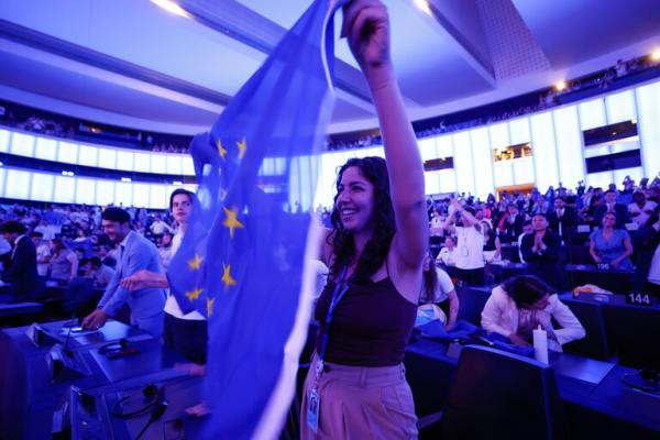 Young woman waving EU flag in European Parliament